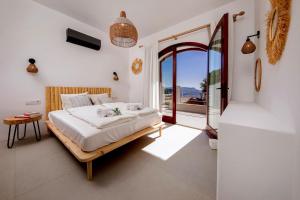 a bedroom with a bed and a large window at Kale Suites, heated pool in winter, adults only in Kaş +46 photos