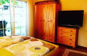 ein Schlafzimmer mit einem Bett mit einer Kommode und einem Flachbild-TV in der Unterkunft Gästehaus Beckord in Hodenhagen