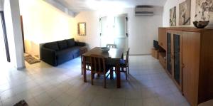uma sala de estar com uma mesa e um sofá em Casa Giummarra al primo piano em San Vito lo Capo