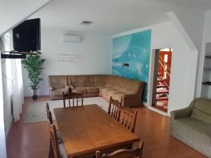 - un salon avec une table et un canapé dans l'établissement Maci Vendégház, à Békéscsaba