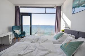 um quarto com uma cama e vista para o oceano em Apartament Nadmorski Luksus - Boulevard em Ustronie Morskie