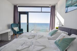 Un dormitorio con una cama con vista al mar. en Apartament Nadmorski Luksus - Boulevard, en Ustronie Morskie