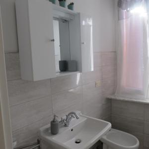een witte badkamer met een wastafel en een toilet bij Volare...oh...oh in Cernobbio