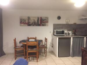 a kitchen with a table and chairs and a microwave at Chez Mimy in Valros