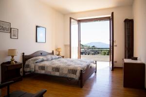 1 dormitorio con 1 cama y puerta corredera de cristal en PANORAMA - Apartment with terrace overlooking the Lake en Massino Visconti