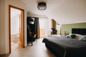 - une chambre avec un lit, un bureau et une fenêtre dans l'établissement SKRI Villa Ružbachy, à Vyšné Ružbachy