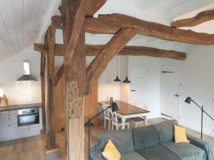 a living room with a blue couch and a table at Ermerhoek: op de Deel in Erm