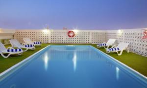 a swimming pool with lounge chairs and chairs around it at Landmark Hotel in Dubai
