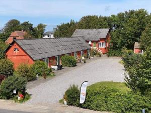 Saltum的住宿－Bed and Breakfast Vester Hjermitslev，享有带车道的红谷仓的顶部景色