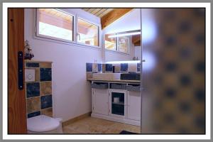 een badkamer met een toilet, een wastafel en een raam bij LES CHAMBRES DE LIANE in Cerdon