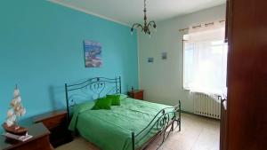 sypialnia z zielonym łóżkiem z niebieską ścianą w obiekcie Casa vacanze da Cristina app B w mieście Maratea