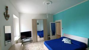 niebieska sypialnia z łóżkiem i telewizorem w obiekcie Casa vacanze da Cristina app B w mieście Maratea