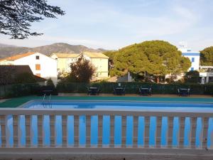 a pool with a fence and a tennis court at Hotel Madame Mere in Saint-Florent