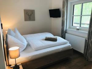 małe łóżko z białą pościelą i poduszkami obok okna w obiekcie Wohlfühl-Appartement Kreischberg inclusive Murau SommerGästeCard w mieście Sankt Georgen ob Murau