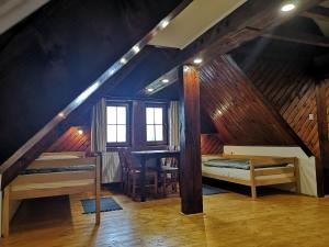 a attic room with two bunk beds and a table at Motorest SKI Čertovica in Liptovská Sielnica