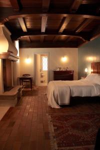 a bedroom with a large bed and a fireplace at Corielli B&B in Malo