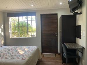 een slaapkamer met een bed, een bureau en een raam bij Halleria Self Catering in White River
