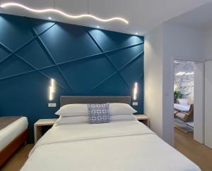 a bedroom with a blue accent wall and a bed at Shangri La Mansion in Mostar