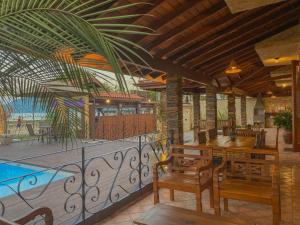a balcony with a table and chairs and a pool at Casa Melville Hospedagem - Sua Casa de Alto Padrão no Coração de Ubatuba! in Ubatuba