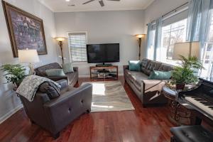 a living room with two couches and a television at Remodeled Historic House Walkable to Everything in Raleigh