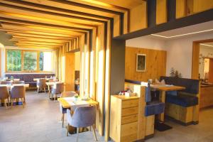 a restaurant with wooden ceilings and tables and chairs at Garten - Hotel Sallerhof in Salzburg