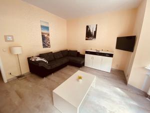 a living room with a couch and a table at Apartment Erfordia Erfurt am Egapark in Erfurt
