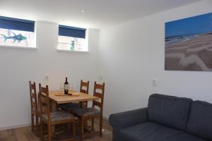 une salle à manger avec une table et un canapé dans l'établissement Heerlijke vakantiehuisjes in Egmond, à Egmond aan Zee