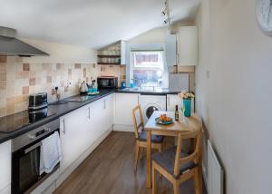 a small kitchen with a table and a small kitchen with white cabinets at 37A Parker House in Salisbury