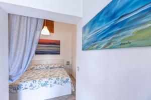 una camera da letto con un letto e un dipinto sul muro di La stanza di Vali a Sperlonga