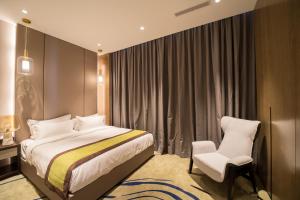 um quarto de hotel com uma cama e uma cadeira em Marigold Hotels em Windhoek