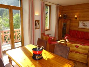 un soggiorno con tavolo in legno e divano di Les Glaciers - Appartement 1 a Chamonix-Mont-Blanc