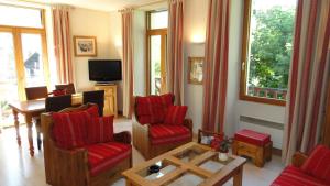 un soggiorno con sedie rosse e TV di Les Glaciers - Appartement 1 a Chamonix-Mont-Blanc