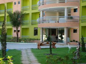 a yellow building with a walkway in front of it at Hotel Absolar in Alagoinhas