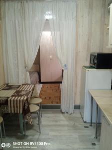 エイスクにあるGuest House Kaskadのテーブルとキッチン付きの小さな部屋