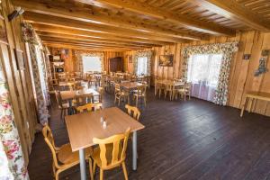 a restaurant with wooden floors and tables and chairs at Trakai Village apartments in Jovariškės