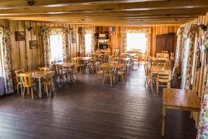 a restaurant with wooden floors and tables and chairs at Trakai Village apartments in Jovariškės +38 photos