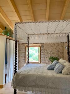 a bedroom with a canopy bed with a window at Can Peñes in Port d’Andratx