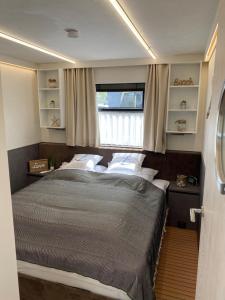 a bedroom with a large bed and a window at Hausboot Buddy in Weyhe