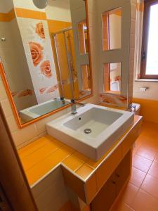 a bathroom with a sink and a large mirror at La terrazza sullo Jonio in Roccella Ionica