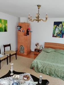 1 dormitorio con cama, mesa y lámpara de araña en CASA ILEA-Agapia", en Agapia