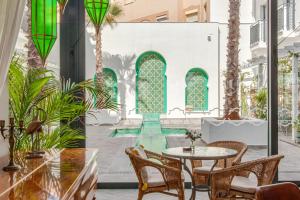 taras ze stołem i krzesłami oraz basenem w obiekcie La Residencia Puerto Hotel & Spa w mieście Tarifa