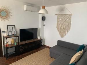 Casa Olalla في ميخاس: غرفة معيشة مع أريكة وتلفزيون بشاشة مسطحة
