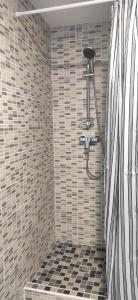 a bathroom with a shower with black and white tiles at Chez Kaïs in Avignon