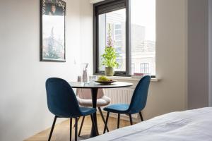 uma sala de jantar com uma mesa e duas cadeiras azuis em Hotel Snouck van Loosen em Enkhuizen