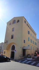 een groot gebouw met een groot raam aan een straat bij Hotel Belvedere in Calvi