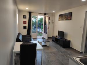 a living room with a table and a television at Chez Kaïs in Avignon