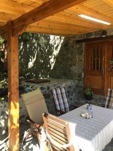 a table and chairs under a wooden pergola at To Spiti tou Faliari in Platanistasa