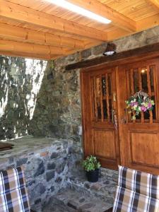 eine Veranda eines Steingebäudes mit einer Holztür in der Unterkunft To Spiti tou Faliari in Platanistasa