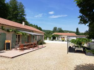 a building with a patio with tables and chairs at La Vergne in Saint-Martin-des-Combes