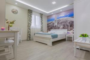 Villa Rita Apartments II في بروماجنا: غرفة نوم بها سرير ولوحة على الحائط